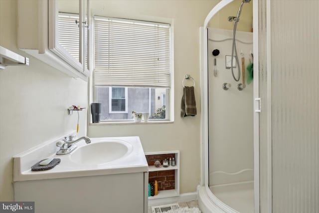 bathroom featuring tile patterned floors, vanity, and a shower with shower door