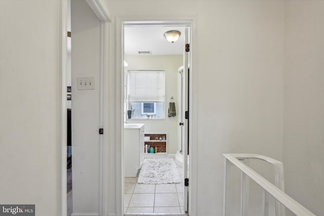 hall featuring light tile patterned floors