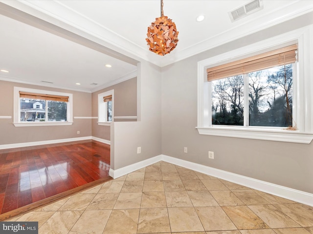 empty room featuring a notable chandelier, light tile patterned flooring, and ornamental molding