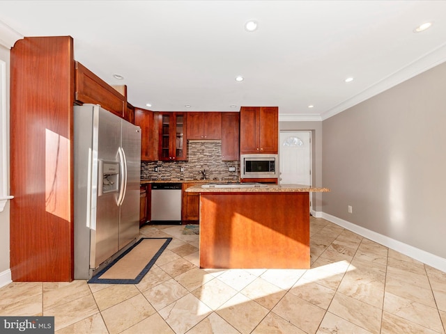 kitchen with a kitchen island, ornamental molding, appliances with stainless steel finishes, and tasteful backsplash