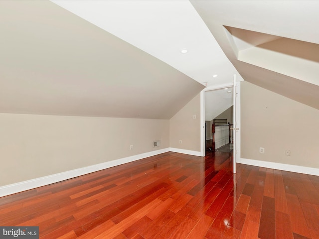 bonus room with wood-type flooring and vaulted ceiling