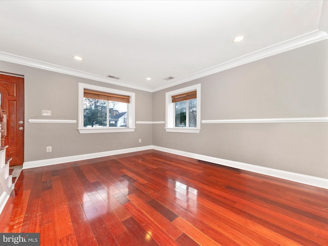 empty room with wood-type flooring and crown molding