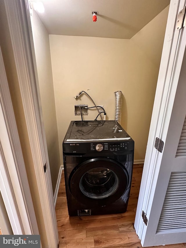 laundry area with light wood-type flooring and washer / clothes dryer