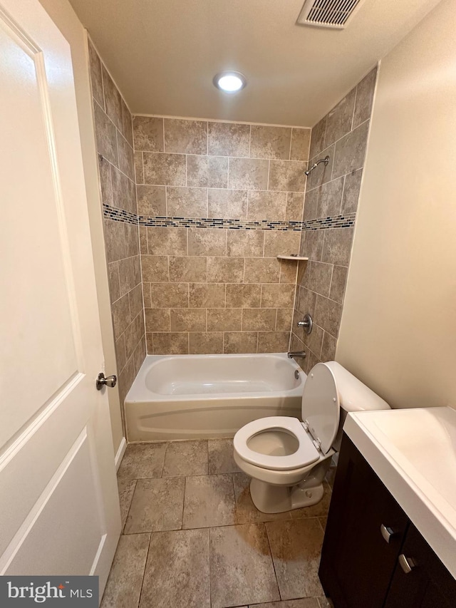 full bathroom with tiled shower / bath combo, toilet, and vanity