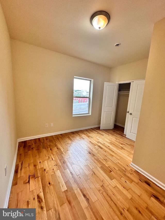 unfurnished bedroom with a closet and light hardwood / wood-style floors