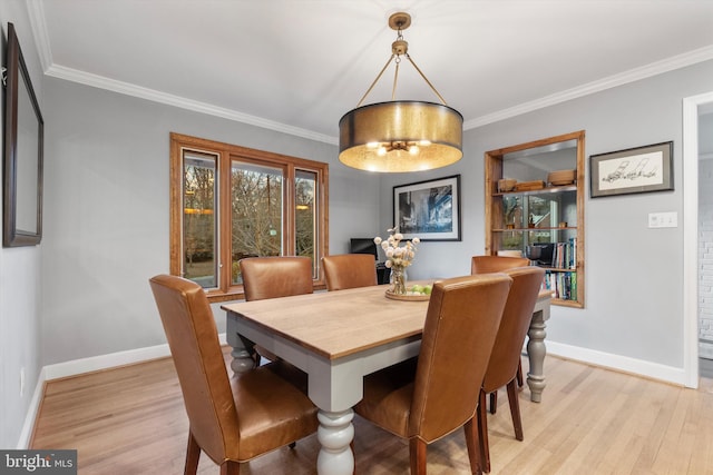 dining area with light wood-type flooring and crown molding