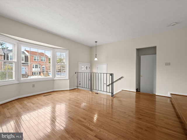 spare room featuring hardwood / wood-style flooring and a textured ceiling