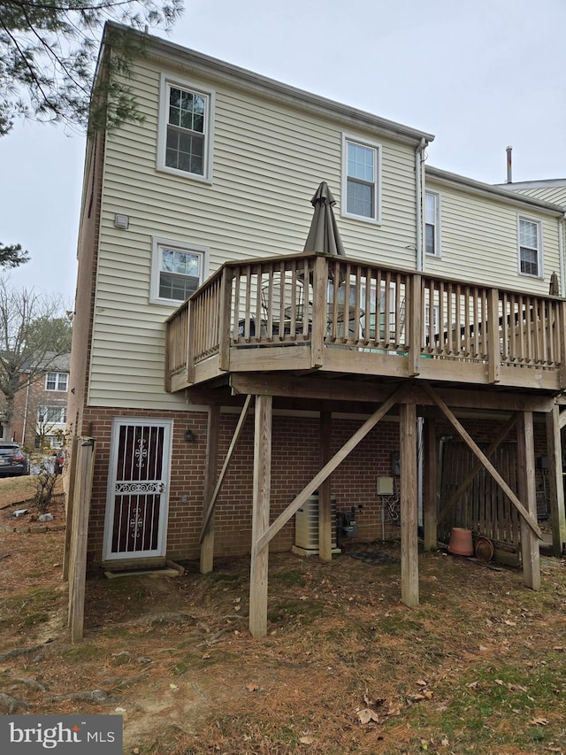 rear view of house featuring a wooden deck and central AC unit