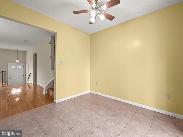 empty room with ceiling fan and light tile patterned floors