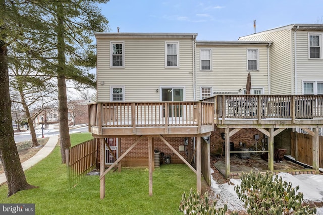 rear view of house with a wooden deck and a yard