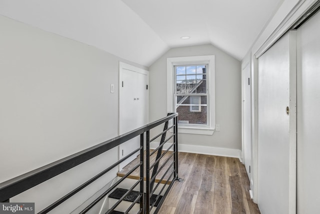 hall with hardwood / wood-style flooring and lofted ceiling