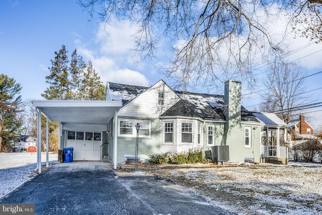 view of front of home with a garage, a carport, and cooling unit