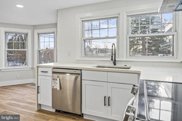 kitchen featuring dishwasher, light hardwood / wood-style floors, white cabinetry, and sink