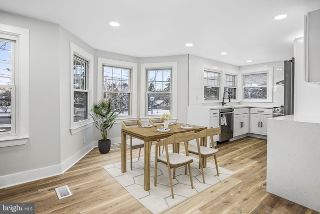 dining room featuring light wood-type flooring and sink