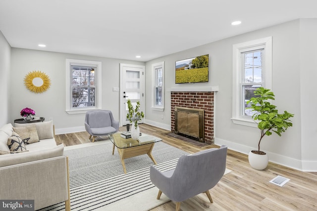 living room with a fireplace and light hardwood / wood-style flooring