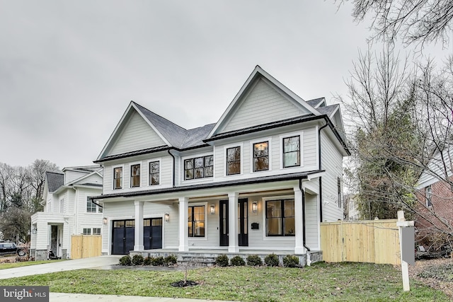 view of front of property featuring a front yard, a porch, and a garage