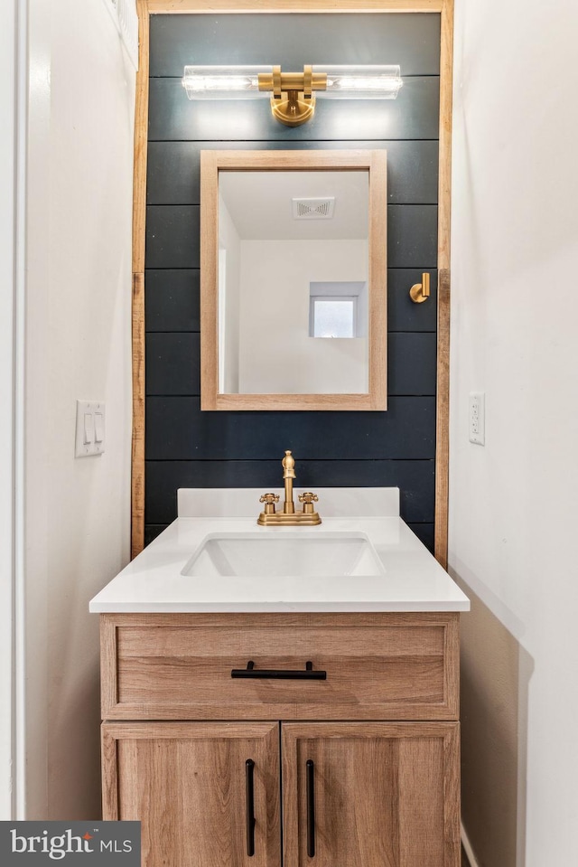 bathroom featuring wooden walls and vanity