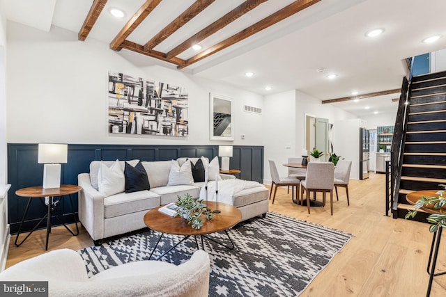 living room featuring beam ceiling and light wood-type flooring