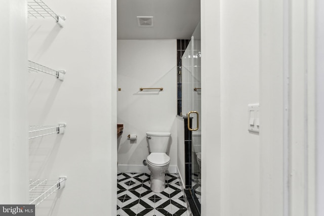 bathroom featuring toilet and an enclosed shower