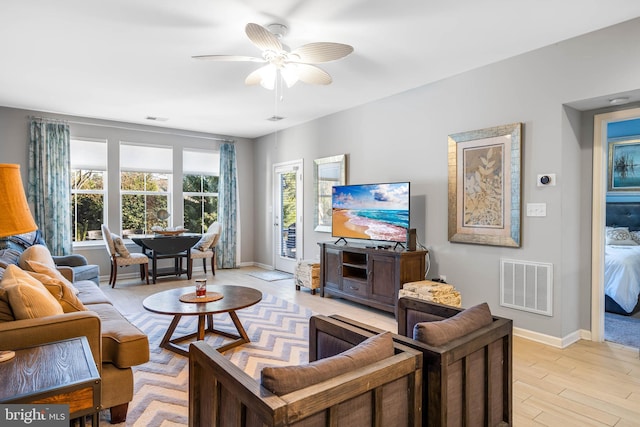 living room featuring ceiling fan and light hardwood / wood-style flooring