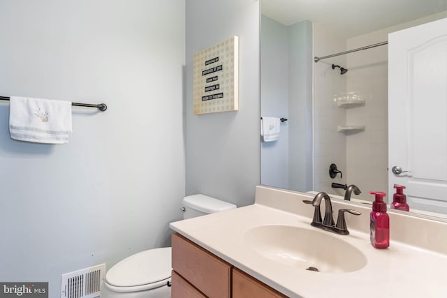 bathroom with vanity, toilet, and a shower