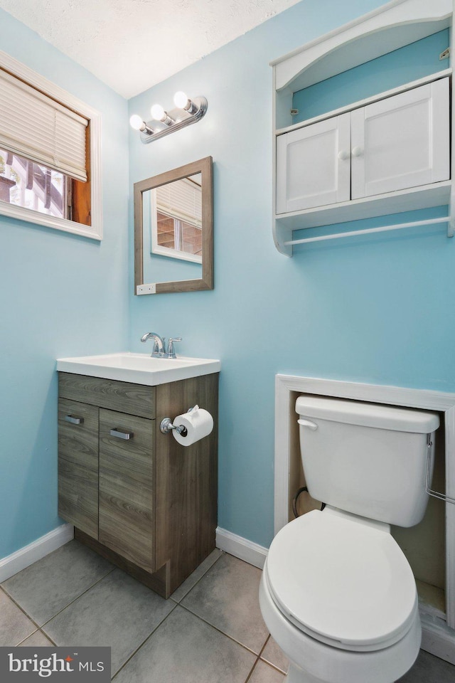 bathroom featuring tile patterned floors, vanity, and toilet