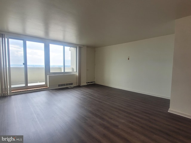 unfurnished room featuring a water view and dark hardwood / wood-style floors