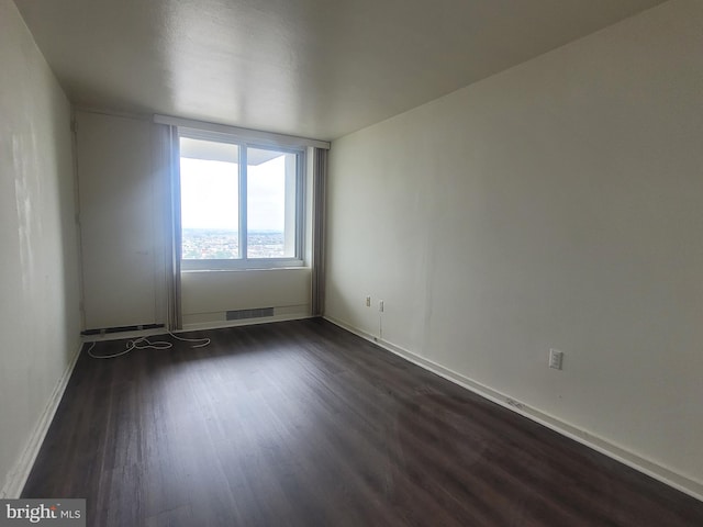 unfurnished room with dark hardwood / wood-style flooring