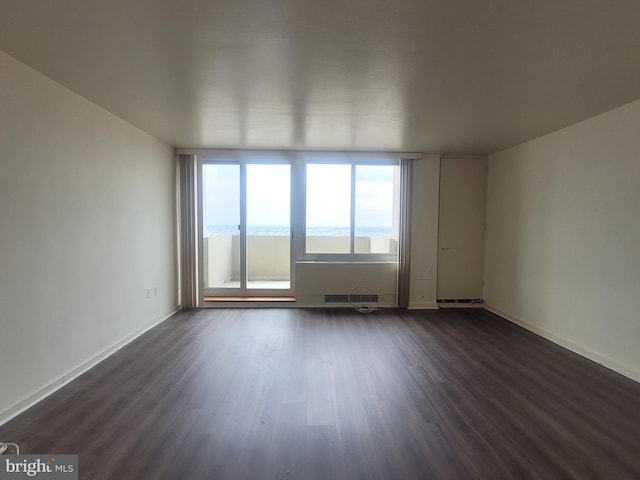 spare room with a water view and dark wood-type flooring