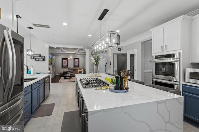 kitchen featuring blue cabinets, stainless steel appliances, white cabinets, and hanging light fixtures