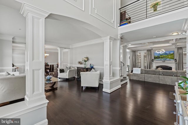 entrance foyer with ornate columns, crown molding, and dark wood-type flooring