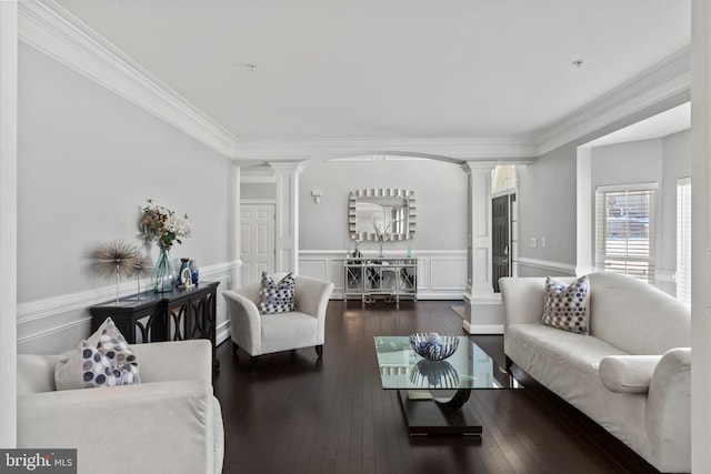 living room featuring crown molding, dark hardwood / wood-style floors, and decorative columns