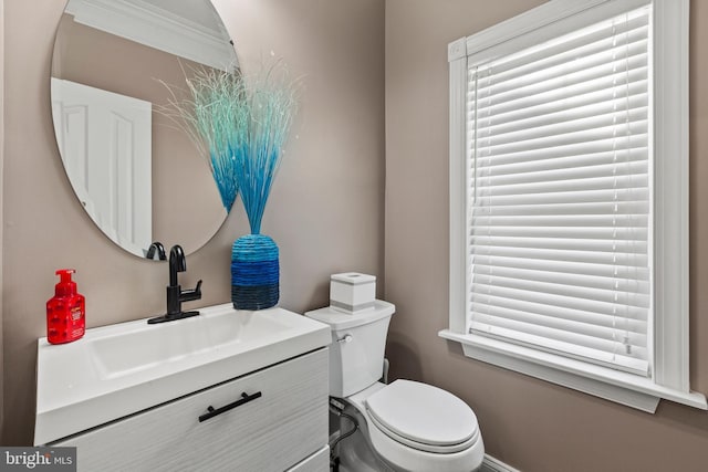 bathroom with ornamental molding, vanity, and toilet