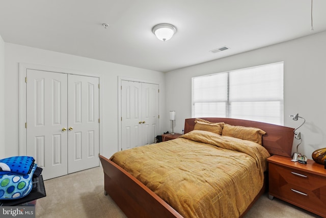 carpeted bedroom with two closets