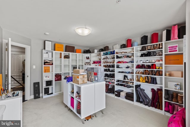 walk in closet with light carpet