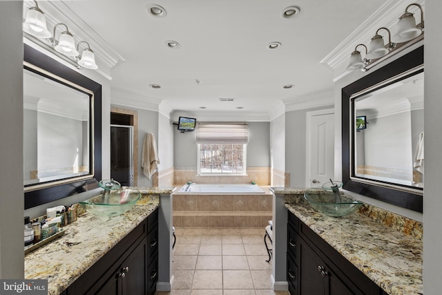 bathroom featuring vanity, tile patterned flooring, crown molding, and tiled bath