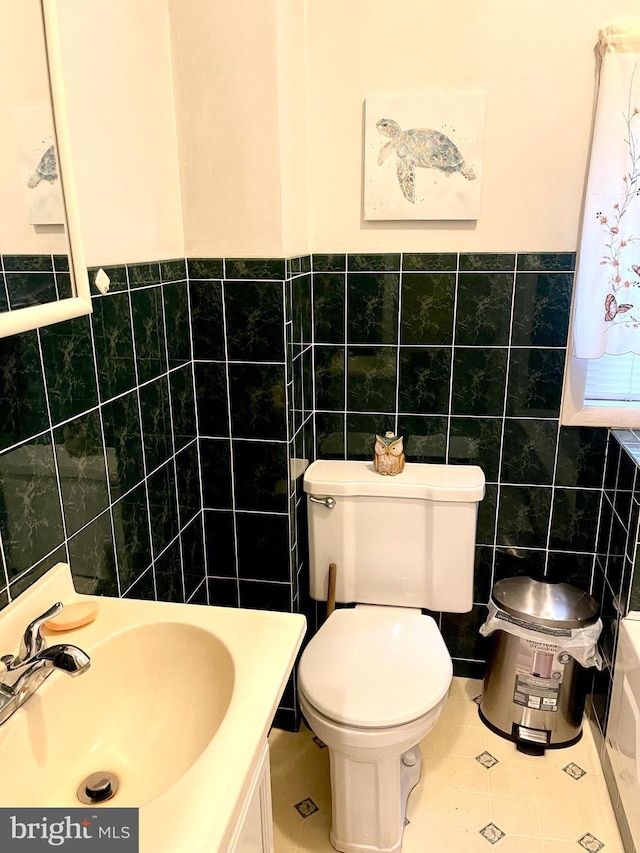 bathroom with tile patterned flooring, vanity, tile walls, and toilet