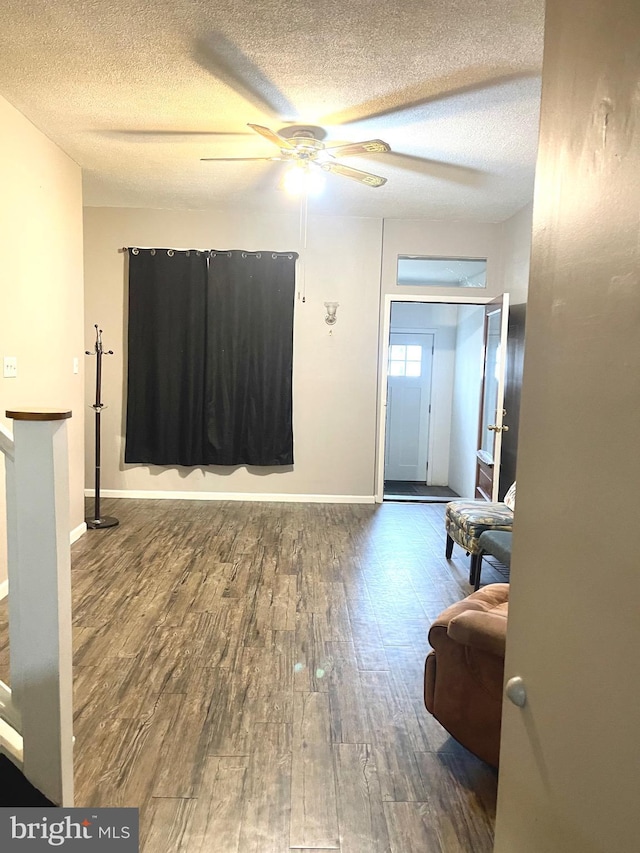 entryway with a textured ceiling, dark hardwood / wood-style flooring, and ceiling fan