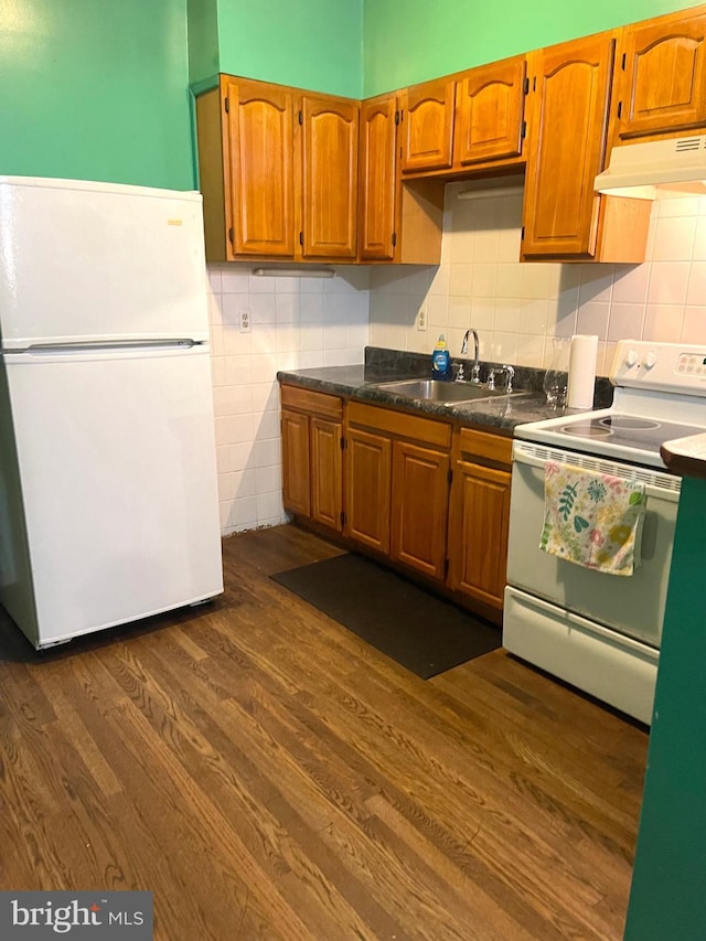 kitchen featuring sink, dark wood-type flooring, and white appliances