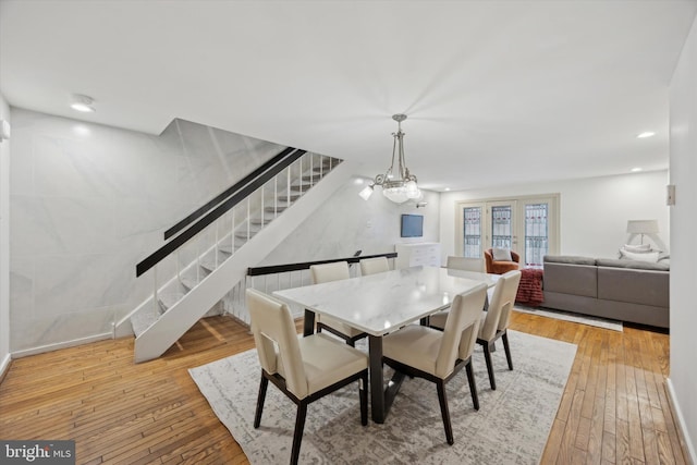 dining room with light wood-type flooring and an inviting chandelier