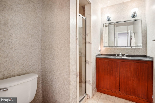 bathroom featuring tile patterned floors, vanity, toilet, and a shower with shower door