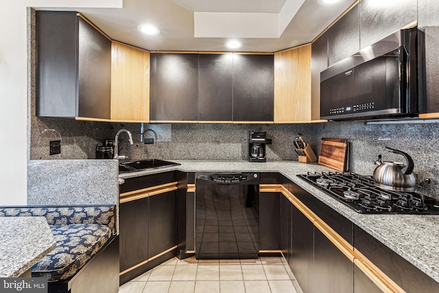 kitchen featuring decorative backsplash, light stone countertops, sink, black appliances, and light tile patterned flooring