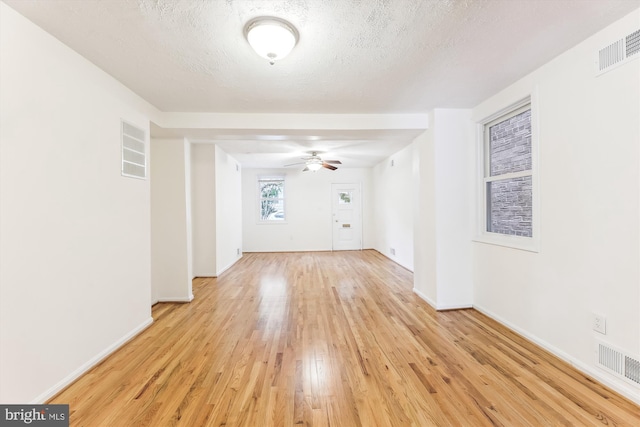 unfurnished room featuring a textured ceiling, visible vents, and light wood-style floors