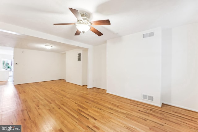 empty room featuring ceiling fan, light wood-type flooring, visible vents, and baseboards