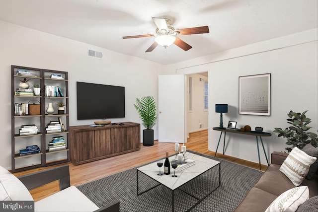 living room featuring light wood-style floors, visible vents, and a ceiling fan