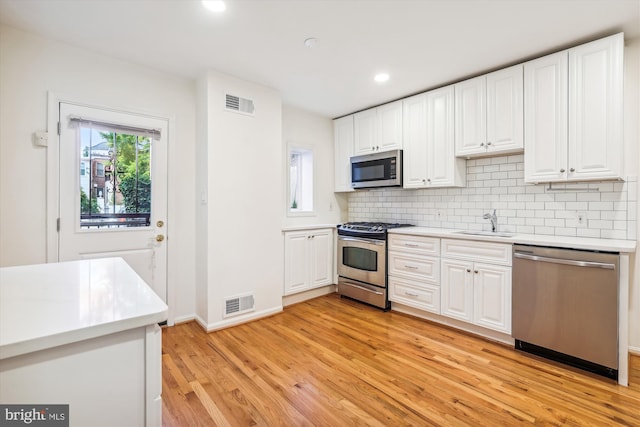 kitchen with stainless steel appliances, visible vents, and white cabinets