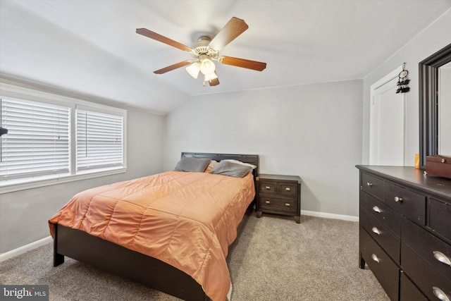 bedroom with ceiling fan, light colored carpet, and vaulted ceiling