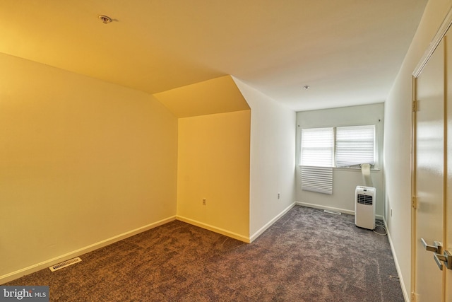 bonus room featuring dark colored carpet and lofted ceiling