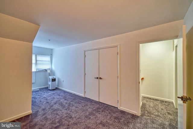 interior space with a closet and dark carpet