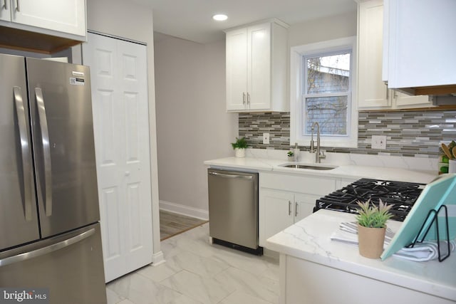 kitchen featuring white cabinets, light stone counters, sink, and appliances with stainless steel finishes